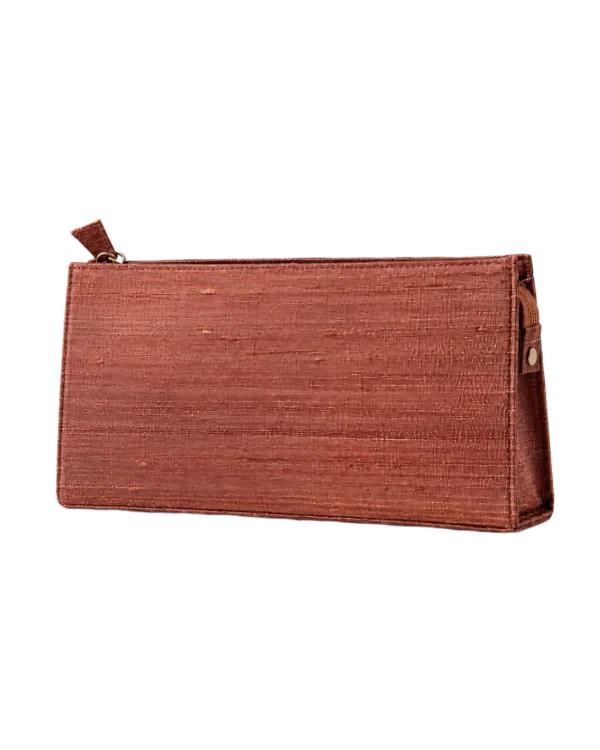 Bronzefarvet clutch med lynlås og struktur på overfladen mod sort baggrund.