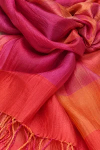 Nærbillede af stof og frynser på et pink og orange tørklæde