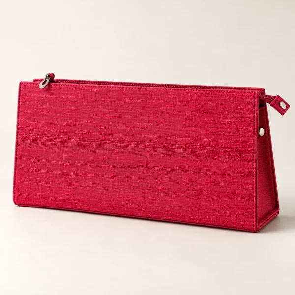 Rød clutch set forfra mod en lys baggrund, med synlig lynlås og metalknap på siden.